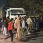 उत्तर प्रदेश के हमीरपुर में एनएच 34 पर हुए सड़क हादसे में क्षतिग्रस्त ट्रक और प्रदर्शन करती भीड़।