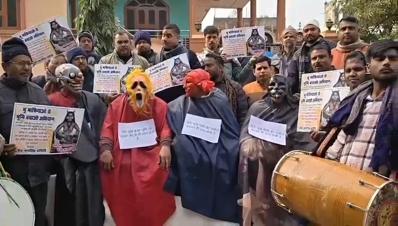 वाराणसी साकेत नगर कॉलोनी में भू-माफियाओं के खिलाफ विरोध प्रदर्शन, चौराहे पर बैठे राक्षस और ढोल नगाड़े की आवाज।